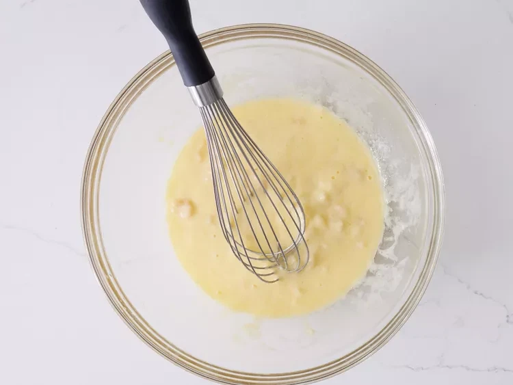 Image of Mix eggs, bananas, oil, and buttermilk together in a large bowl until well combined.
