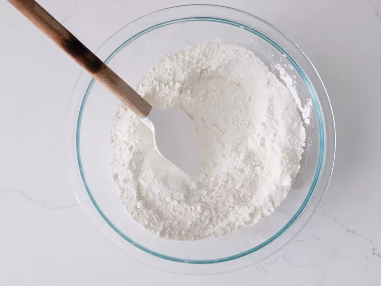 Image of Sift flour, sugar, baking soda, and salt into a separate large bowl.