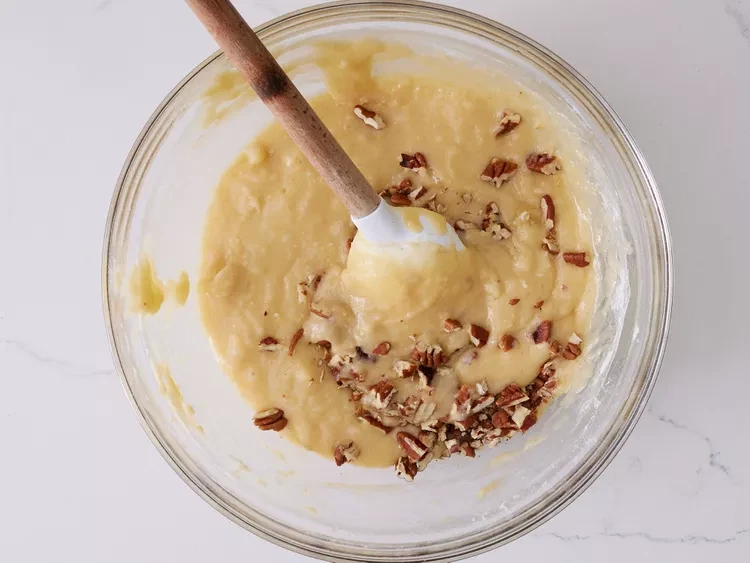 Image of Stir flour mixture into the banana mixture until combined. Gently fold in pecans.