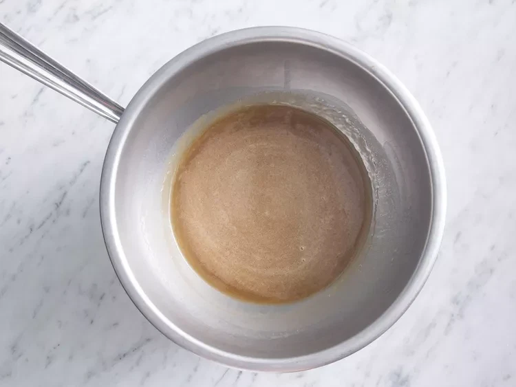 Image of Heat corn syrup, honey, and butter in the top half of a double boiler; keep glaze warm while baking ham.