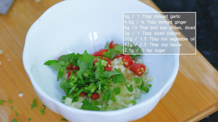 Image of To make the dipping sauce, add the minced garlic, ginger, cilantro, and optionally diced Thai bird’s eye chilies into a heat-proof bowl.