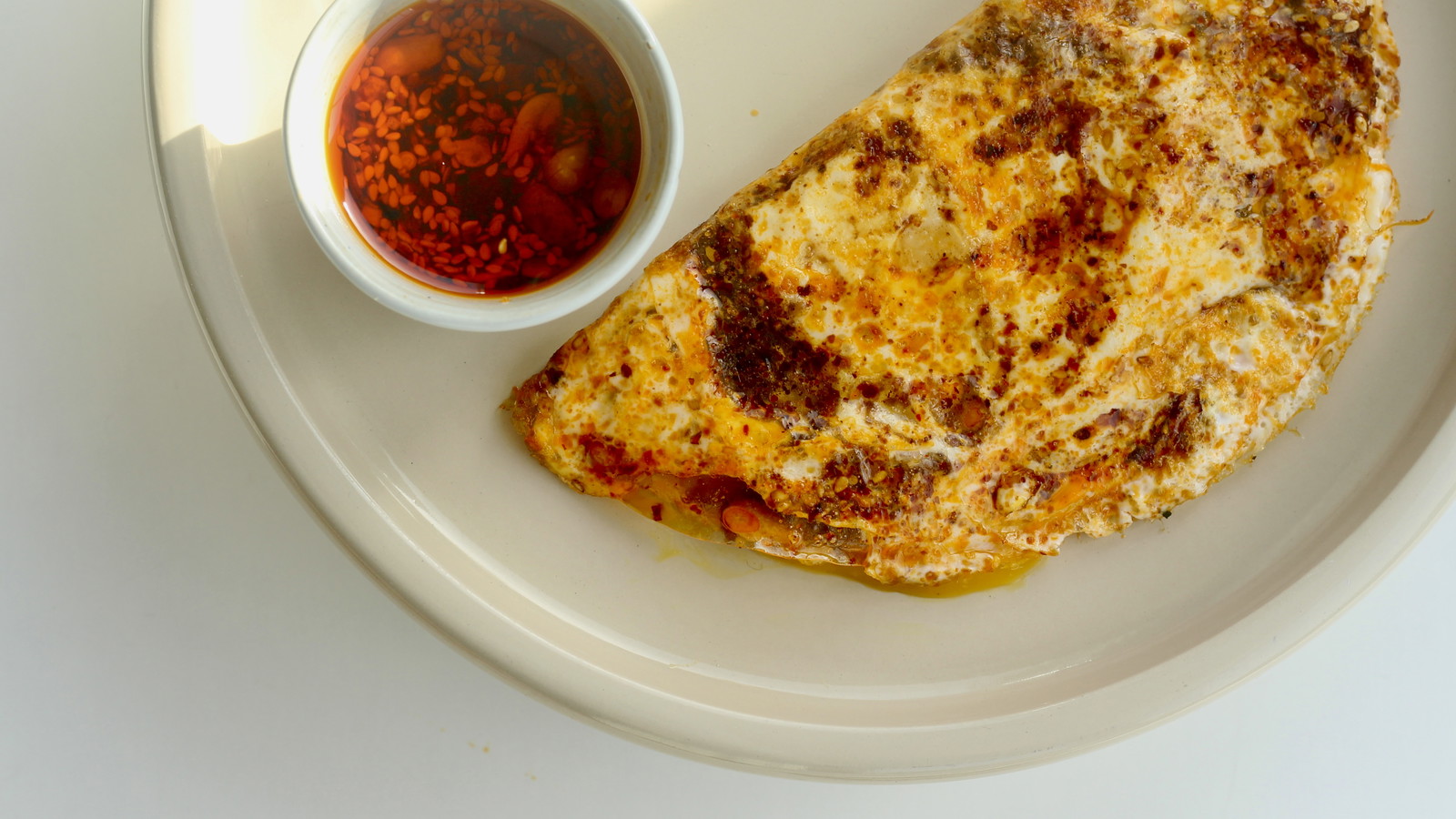 A delicious picture of a Rice Paper Omelette with White Mausu Extra Hot Peanut Rāyu. 
