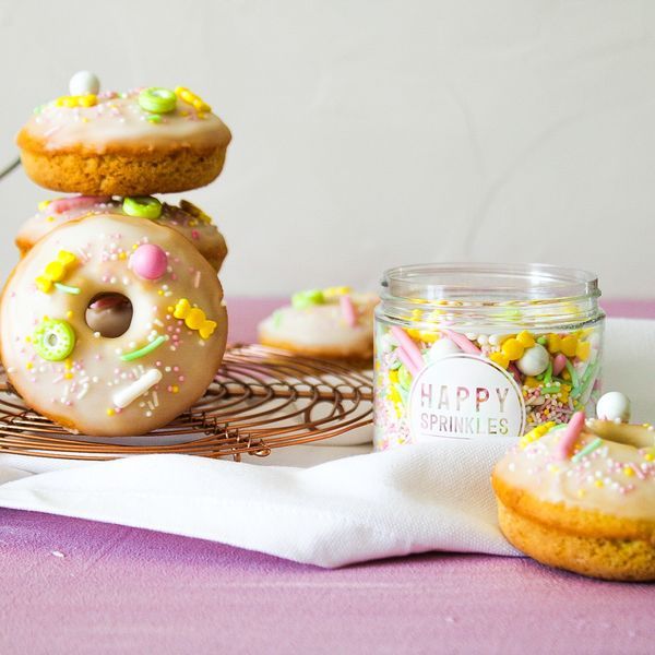Image of Die Donuts etwas abkühlen lassen, aus der Form lösen und auf einem Kuchengitter vollständig abkühlen lassen. Für den Guss Puderzucker mit dem Zitronensaft zu einem dickflüssigen Guss verrühren. Einen Kuchenrost auf ein Stück Backpapier stellen. Die Donuts mit der Oberseite...