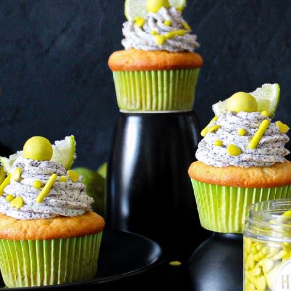Image of Für die Deko die Limette heiß abwaschen, trockenreiben und in 6 Scheiben schneiden. Jede Scheibe halbieren und in etwas Zucker drücken. Auf jeden Cupcake eine halbe Limettenscheibe setzen und mit den grünen Streuseln dekorieren. 