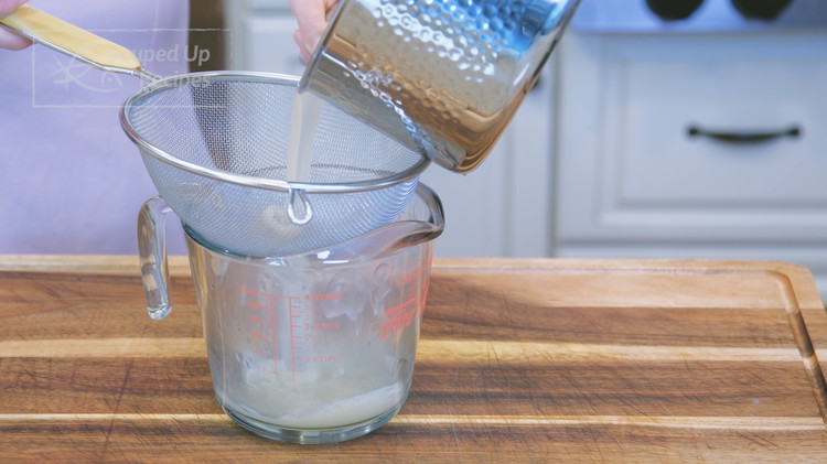 Image of Pour the soup through a sieve into a measuring cup. If you have more than 1 ¾ cup (about 420g), reduce it on the stove. If you don't have enough, add some water.