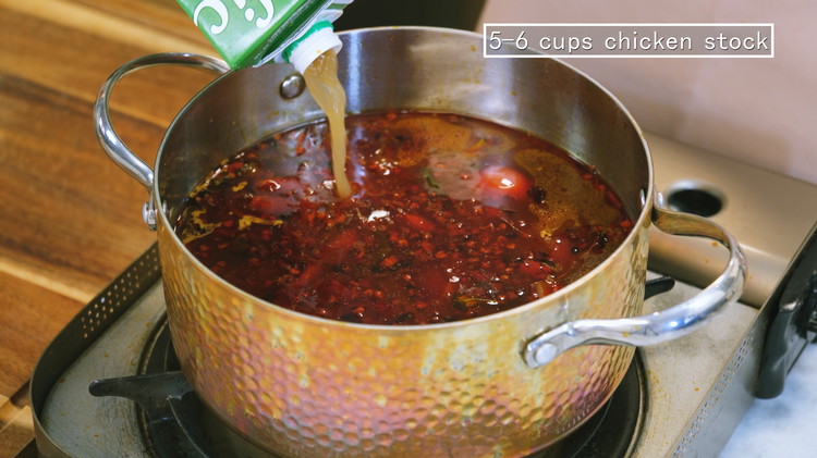 Image of Pour in 5-6 cups of chicken stock or water and bring it to a boil.