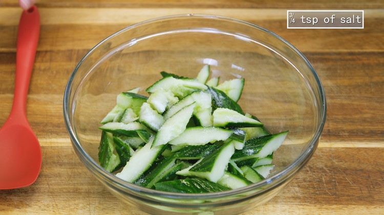 Image of Cut the smacked cucumber diagonally into bite-size pieces. Season it with 3/4 tsp of salt. Toss thoroughly and set it aside for 15 minutes.