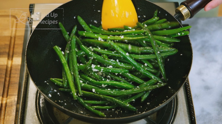 Image of Push the green beans to the side of the wok so you have room to add 1 tsp of vegetable oil and 2 Tbsp of finely minced garlic. Stir until fragrant, then mix until the garlic bits cling to the...