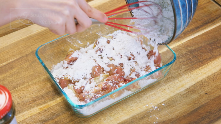 Image of Combine 1/3 cup of cornstarch and 1/3 cup of flour in a bowl and stir well. Use half of the flour mixture to cover the bottom of a container. Then add the marinated chicken and spread it out. Cover the chicken...
