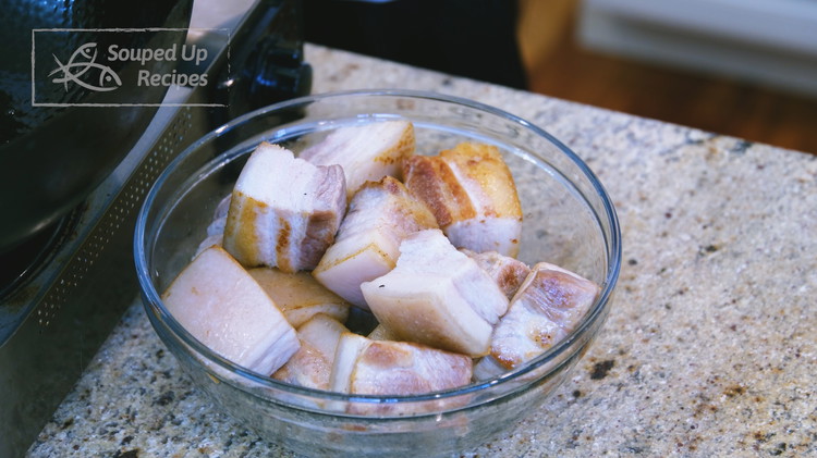 Image of Remove the pork from the wok but leave the oil behind. Please clean any residue left from rendering the pork fat; otherwise, it will burn while caramelizing the sugar and bring a bitter taste.