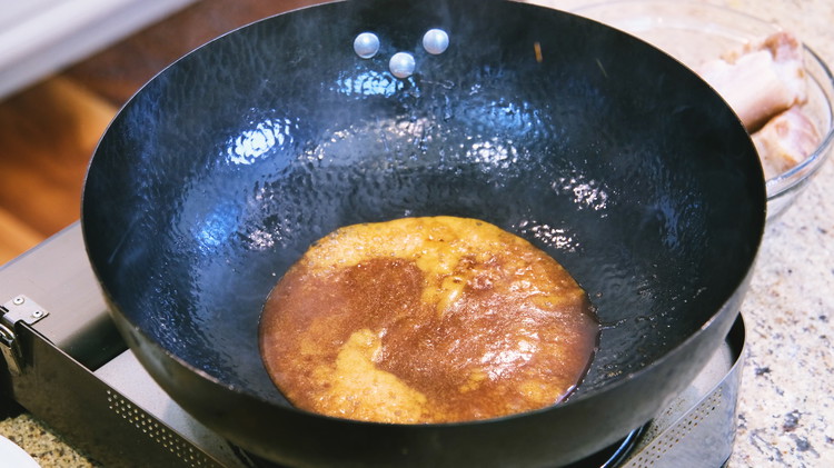 Image of Add the sugar to the wok and stir over low heat for about 3-4 minutes or until it is caramelized.