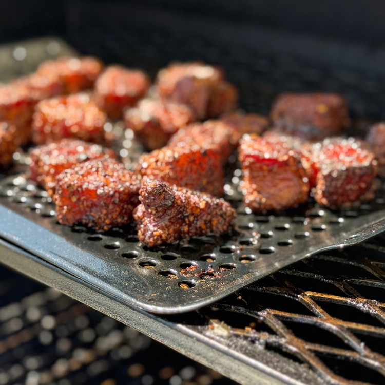 Image of Smoker Method: Set your smoker to 250°F. Place the seasoned pork belly cubes on a wire rack or directly on the grates. Smoke for 2–3 hours until the fat starts rendering and the edges are crispy. Spritzer with apple cider...