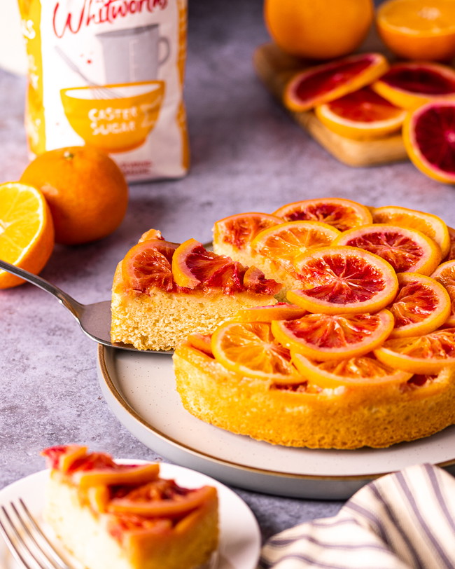 Slice taken out of an Orange up-side cake served on a plate