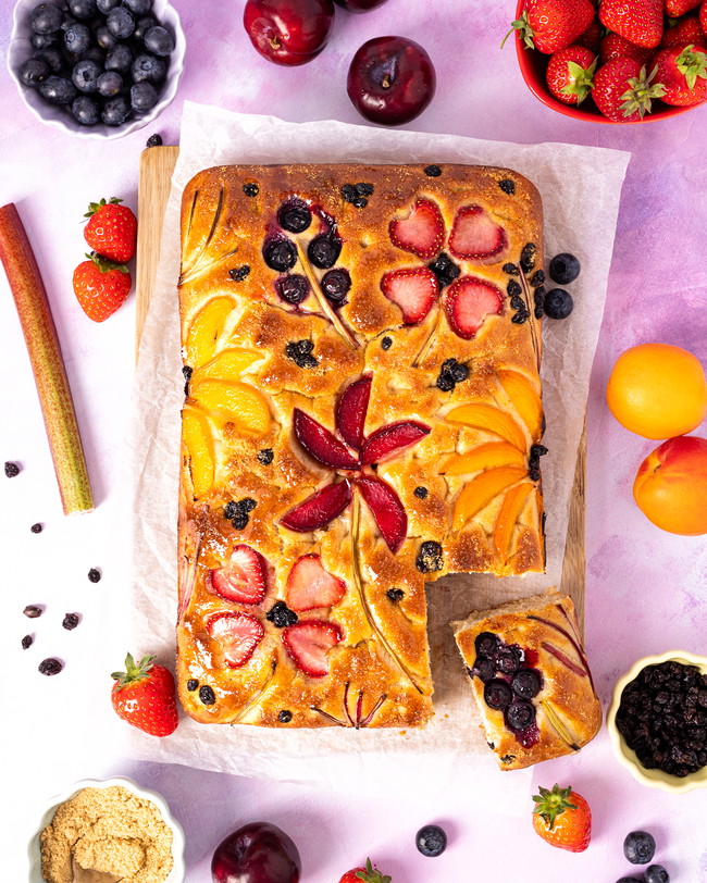 Sweet focaccia decorated with seasonal fruits making flower shapes
