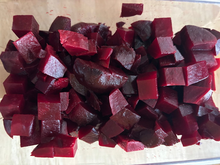 Image of Slice the beets into ½ inch slices, then use the Alligator Chopper to dice them into perfect pieces. Image is a 17.6oz bag of Gefen whole, peeled, cooked & ready-to-eat beets chopped. Use only 1 Cup for salad.