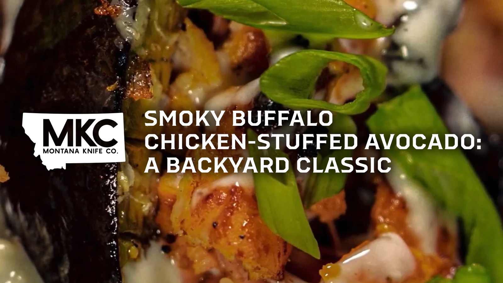 Close-up of a smoky buffalo chicken-stuffed avocado topped with chopped green onions and drizzled with creamy sauce.