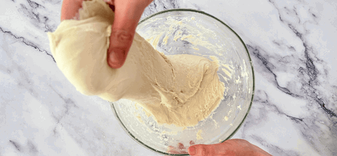 Image of Wet your hands first to stop the dough sticking, then fold the dough 4 times clockwise from top to bottom (handle gently to keep the bubbles inside the dough) 