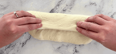 Image of Take the top edge of the dough and fold it halfway, like you're folding a letter.