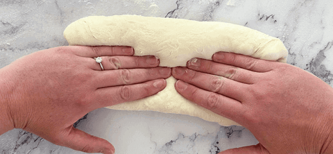 Image of Press into the dough with the edge of your hand to seal it. Flip the dough 180 degrees and repeat this step. 