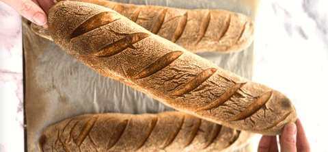 Image of Place baguettes onto a lined baking sheet and make 3-5 diagonal scores across each one using your bread lame.