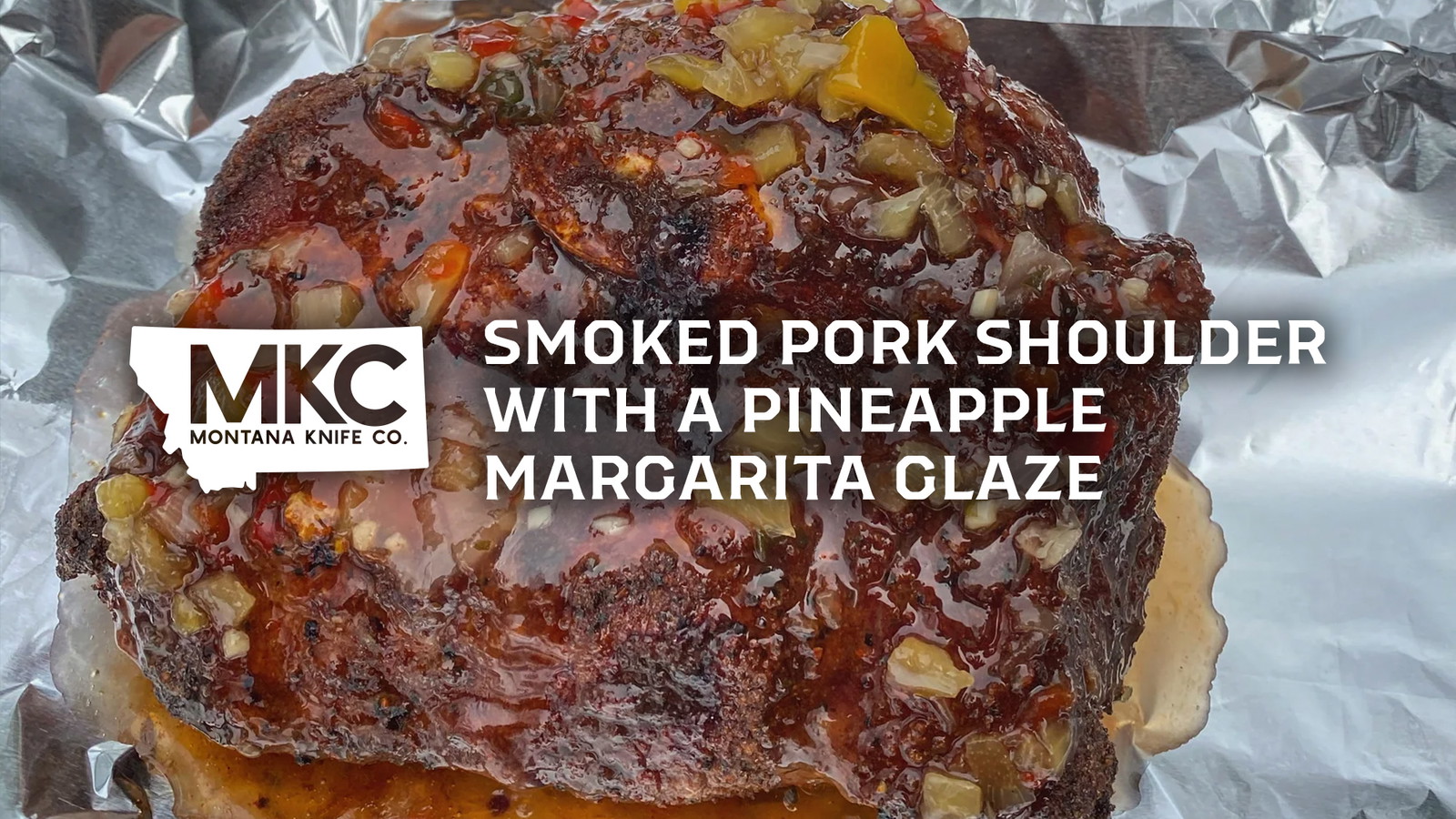 Smoked pork shoulder topped with pineapple margarita glaze on foil.