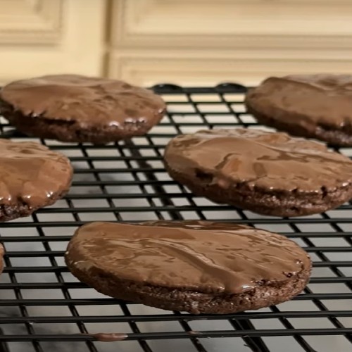 Freshly baked triple chocolate mint cookies on a wire rack.