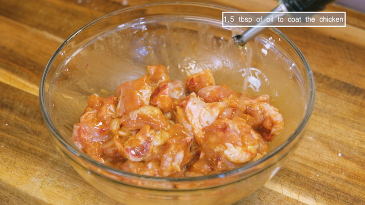 Image of Drizzle in 1.5 tbsp of cooking oil and stir to coat the chicken. This helps to separate the pieces so they don't stick together while deep frying.
