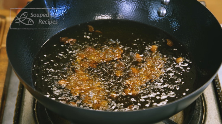 Image of Add 2 cups of oil and the soaked but drained peanuts to a wok. Turn the heat to medium and stir every 30 seconds or until the peanuts become crispy. This will take about 3-5 minutes. Peanuts burn easily so...