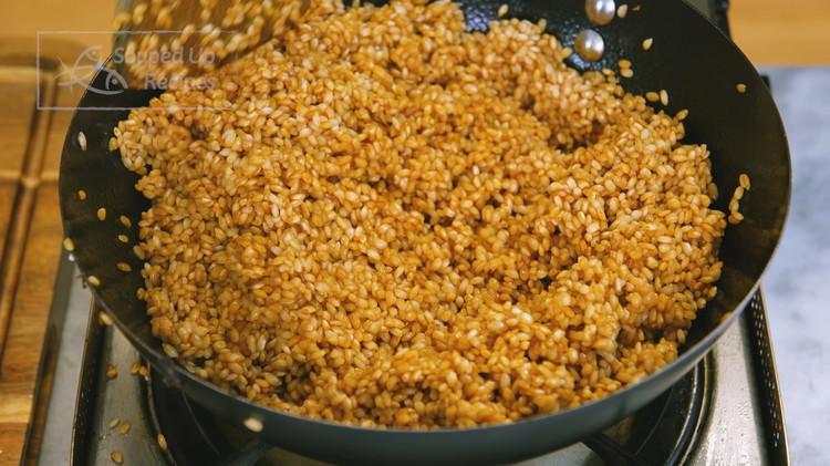 Image of Turn the heat to medium and add a few tablespoons of cooking oil, the soaked glutinous rice, and 1 Tbsp of dark soy sauce. Stir over medium heat for a few minutes, or until the grains become slightly sticky, so it...