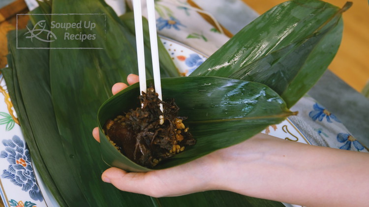 Image of Add two pieces of pork, along with some Maigancai, then fill up the rest of the space with more glutinous rice.