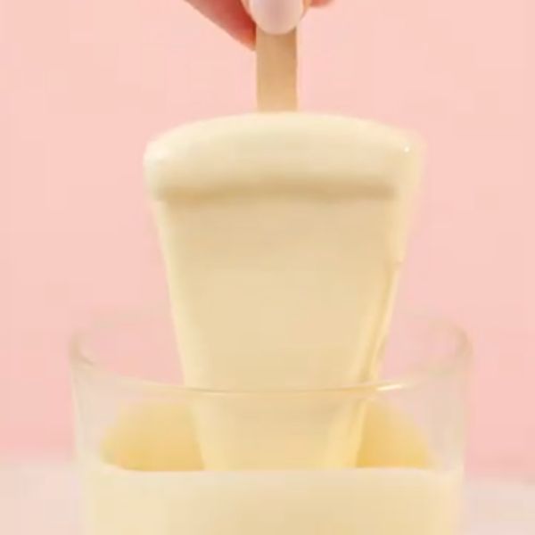 Image of Die gefrorenen Cheesecake-Sticks in geschmolzene Kuvertüre tauchen. 