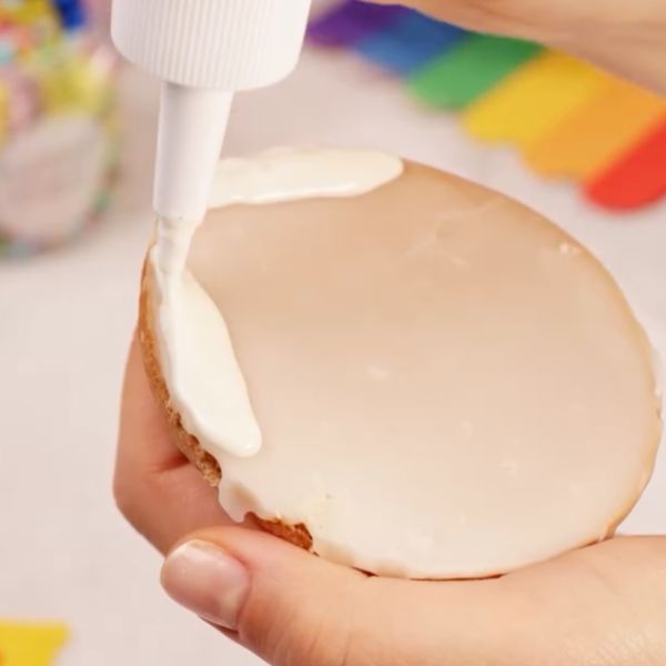 Image of Clown aufsetzen: Verteile ein wenig Creamy White Drip auf einer Seite des Amerikaners und drücke den fest gewordenen Hut vorsichtig daran.