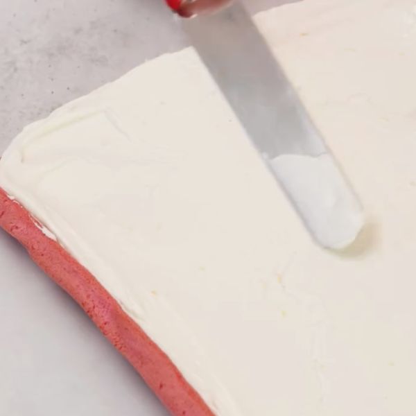 Image of Biskuit vorsichtig entrollen, mit der Creme bestreichen und nach Belieben mit frischen Erdbeeren oder Himbeeren belegen.