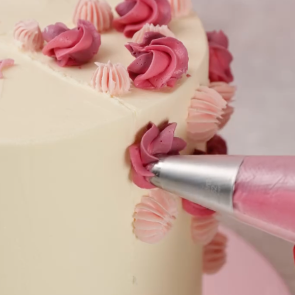 Image of Mit verschiedenen Tüllen aus dem Happy Sprinkles Tüllenset kleine Blumen, Swirls und Tuffs aufspritzen. Mit Streuseln und ggf. frischen Blüten toppen. Den Rest der Torte schlicht lassen oder dezent verzieren.