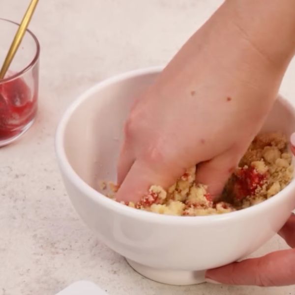 Image of Erdbeeren in kleine Stücke schneiden. Erdbeermarmelade und gestückelte Erdbeeren nach und nach unterkneten, bis eine formbare, saftige Masse entsteht.