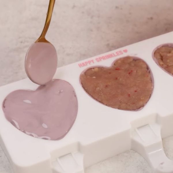 Image of Die Schokolade auf die gefrorenen Herz-Cakesicles in der Form geben...