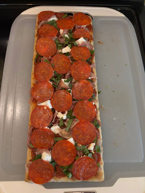 Image of Place the sliced Pepperoni evenly onto the pizza.