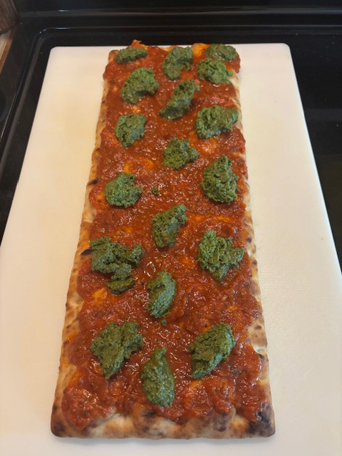 Image of Spoon the pesto and drop the dallops somewhat evenly over the sauce.