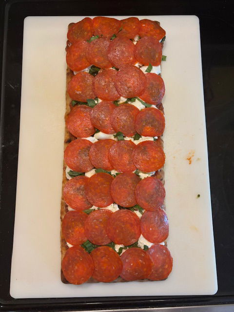 Image of Place the sliced Pepperoni evenly onto the pizza.