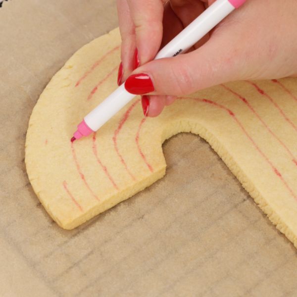 Image of ✏️ Tipp: Zeichne mit einem essbaren Lebensmittelfarbstift dünn die einzelnen Bögen auf den Keks vor – so gelingt das Auftragen des Icing besonders sauber.