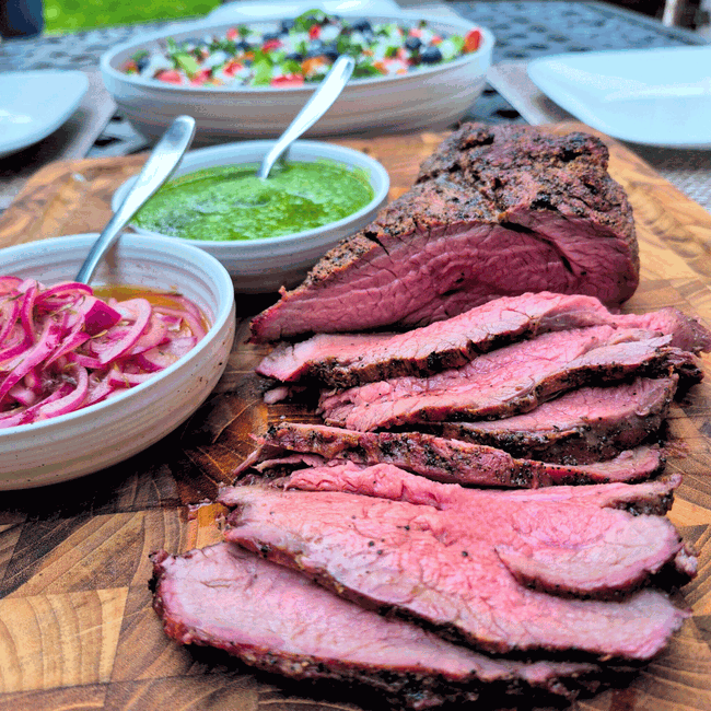 Sliced Bison Tri Tip on board with pesto 