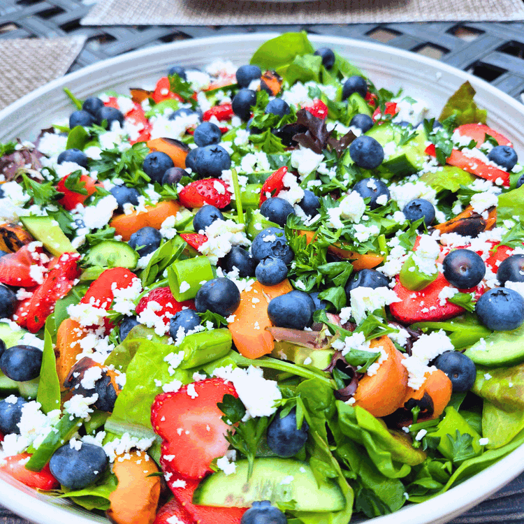 Image of Top with the romaine, berries, grilled apricots, sliced peas, cucumbers, and feta cheese. Dress with a balsamic vinaigrette or glaze.