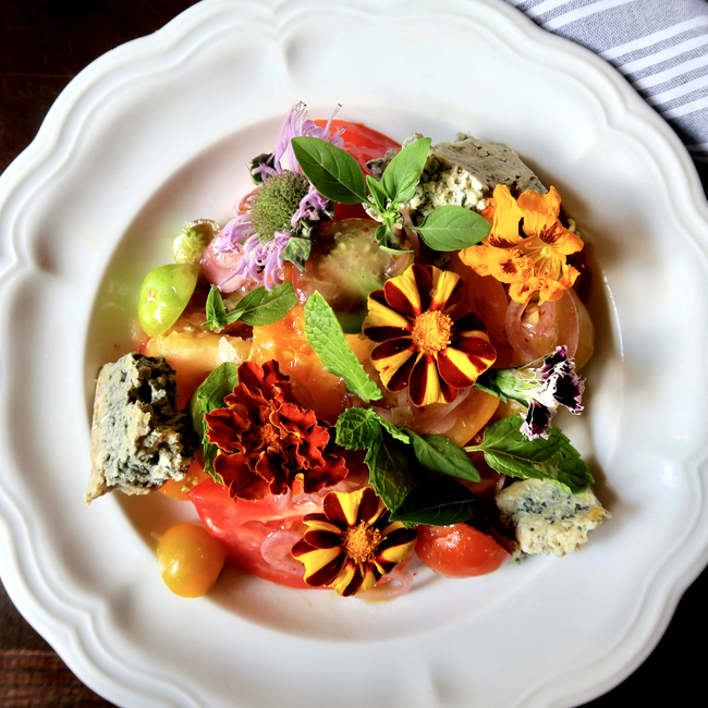 Image of heirloom tomato salad with edible flowers, blue cheese & herbs