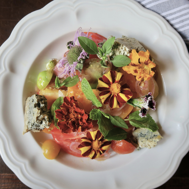 Image of heirloom tomato salad with edible flowers, blue cheese & herbs