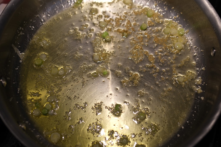 Image of Add olive oil to large pan at medium heat and add grated garlic and green onion whites. 