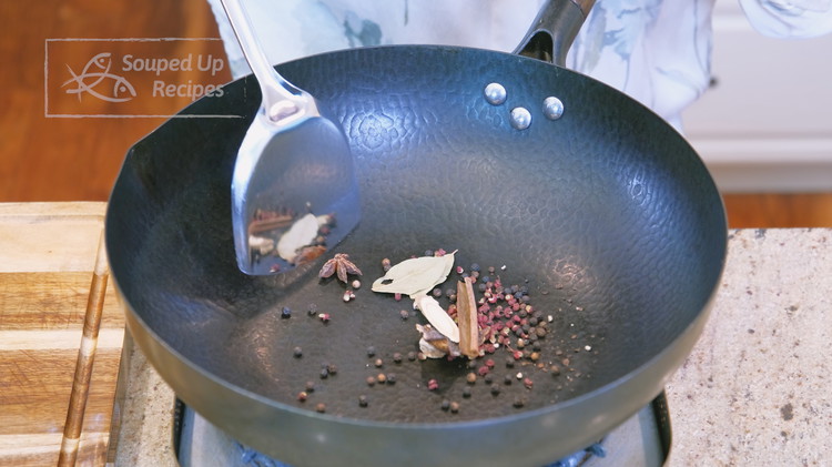 Image of Toast the black peppercorns, Sichuan peppercorns, star anise, bay leaves, cinnamon stick, dried gancao (licorice root), dried sand ginger, and aged tangerine peel in the wok over low heat for 2 minutes. 