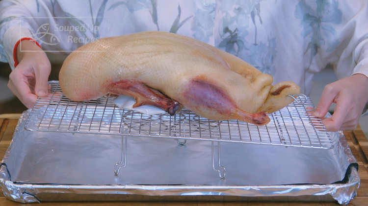 Image of Wrap the baking pan with tinfoil for easy cleaning. Place the duck on the baking rack, breast side up. Optionally, put an extra steamer rack under to lift the baking rack so there is plenty of space between the duck...