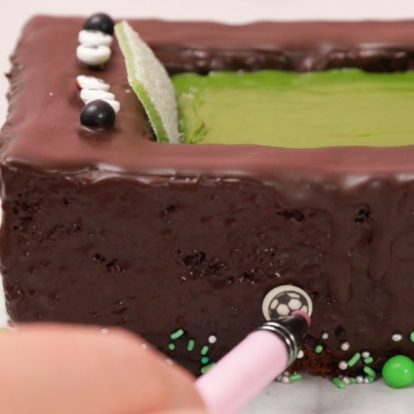 Image of Verziere den unteren Kuchenrand mit dem „Football Champion“ Streuselmix.