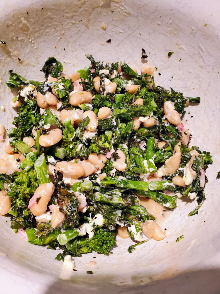 Image of Mix broccoli rabe, beans, shallots with vinegar, salt, olive oil, and goat cheese together well.  You want to make sure the cheese is evenly spread throughout the dish.