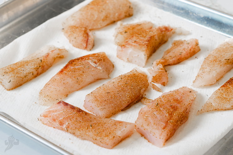 Image of Once dry, sprinkle fish all over with jerk rub and set on a plate and set aside to marinate for a few minuites while we make the salsa. 